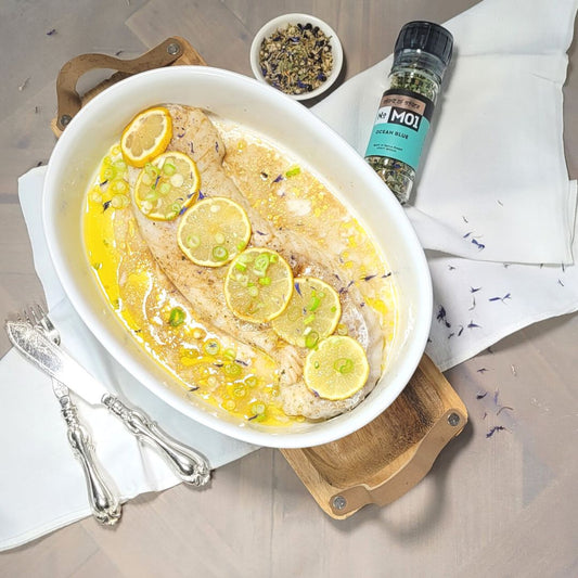 Fisch Kabeljau in weisser Schüssel, belegt mit Zitronenscheiben und Frühlingszwiebeln, gewürzt mit Ocean blue von Soirit of Spice