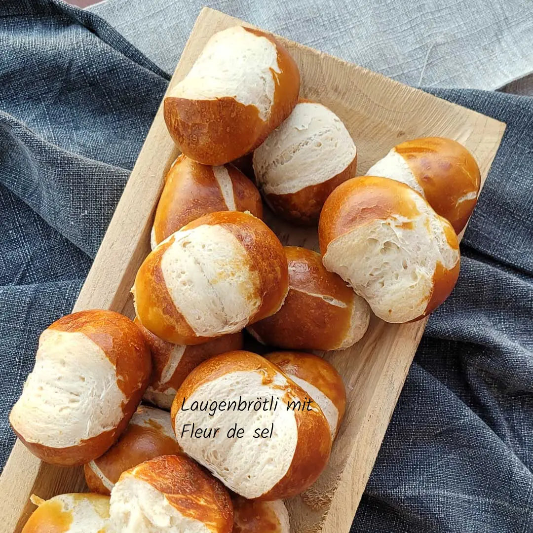Laugenbrötli mit Fleur de Sel - goldbraun gebacken, knusprig und veredelt mit feinem Meersalz, ein klassisches Schweizer Gebäck mit edler Note.