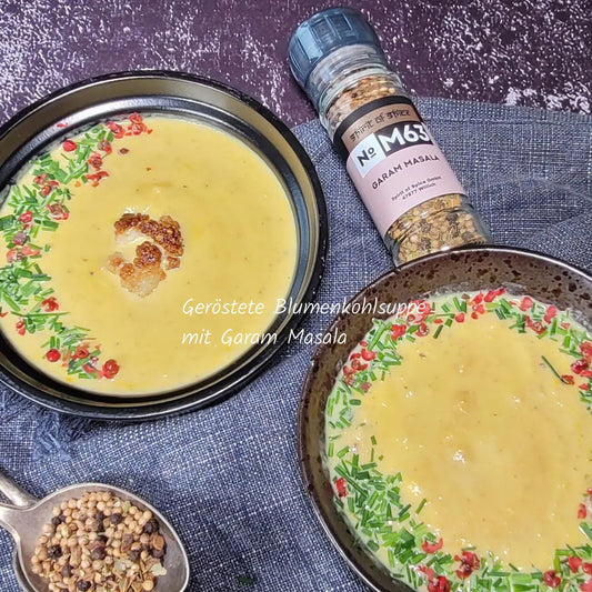 Geröstete Blumenkohlsuppe verfeinert mit Garam Masala indische Gewürzmischung cremige Suppe mit Blumenkohl frischen Kräutern und rosa Pfefferkörnern aromatisches vegetarisches Rezept